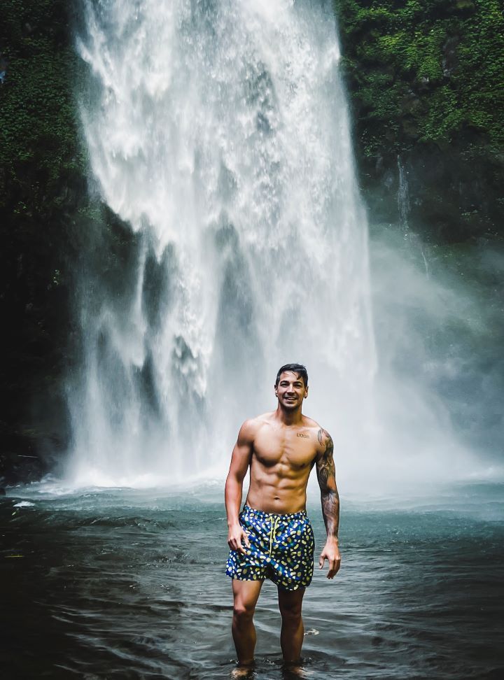 cascada de bali con chica de frente en bañador mirando a la camara